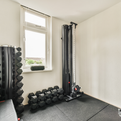 home gym mini split dumbbells stacked under a window in a home gym