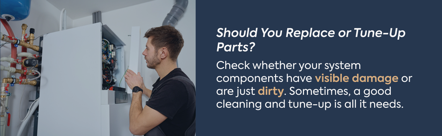 Should You Replace or Tune-Up Parts? text: Check whether your system components have visible damage or are just dirty. Sometimes, a good cleaning and tune-up is all it needs. image: an HVAC technician performing a visual inspection on a piece of indoor equipment